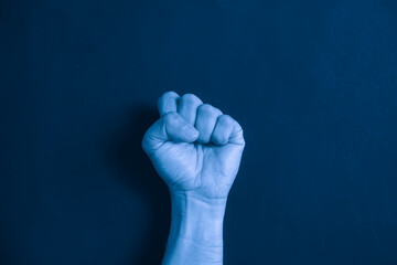 Closeup of Man Punch. A striking image capturing a fist, symbolizing strength and determination, against a vibrant blue color filter background