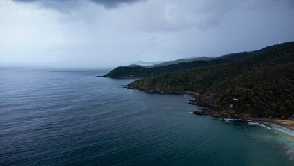 

Aerial view of Nagtabon Beach in Palawan Philippines following heavy rains. stormy clouds and waves lapping onto the beach.