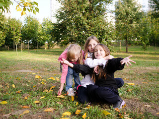 Joyful children three little girls playing in the autumn park