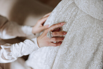 close-up of female hands touching dress. Women's manicure. A luxurious wedding ring on a woman's finger.
