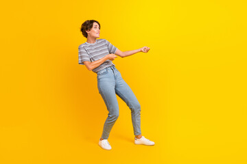 Fototapeta na wymiar Full length profile photo of focused hardworking person biting lips arms pull empty space isolated on yellow color background