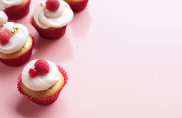Cupcakes with cream and raspberries on a pink background, overhead view