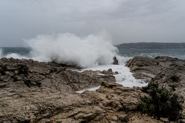 Fototapeta na wymiar Waves crashing during storm on a rocky shore. High quality photo. Climate natural event weather