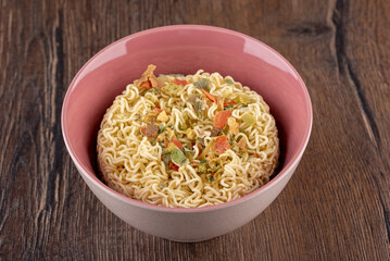 Bowl with dry instant noodles and dry ingredients and spices.
