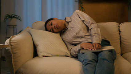 Tired exhausted African American businesswoman night working laptop from home overworked woman fall asleep on couch sick weary sleeping female flopped down on sofa chronic fatigue lack energy relaxing