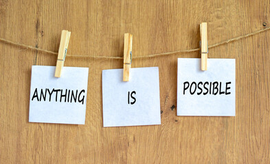 Anything is possible symbol. Concept words Anything is possible on beautiful white paper on clothespin. Beautiful wooden table wooden background. Business anything is possible concept. Copy space.