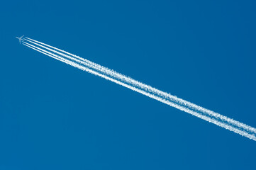 Airplane contrails in Blue Sky for use as a background - obrazy, fototapety, plakaty