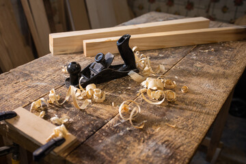 Carpentry tool. Hand plane. Old tools. Joinery tool. Wood shavings, chip. Wooden table and boards, rails