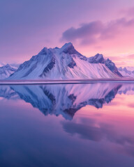 Snow-capped mountains reflected in tranquil waters under a pastel sky 