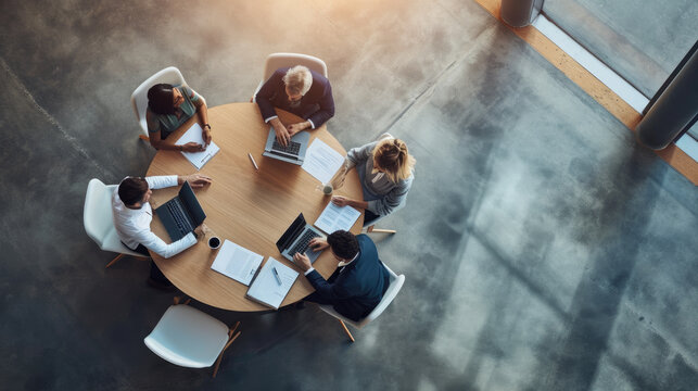 Aerial view of a professional meeting with four individuals around a round table