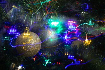 A selective shot of decorations and lights on a decorated Christmas tree. Abstraction of Christmas lights.