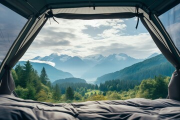 View from inside an open camping tent from the sleeping place to the beautiful snowy green mountains landscape. Concept of mountaineering, tourist recreation and sport