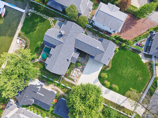 Aerial View of Luxurious Suburban Homes with Lush Gardens and Waterfront