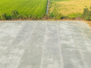 Drone high angle shot The yard is used for drying rice from the rice mill in the rice fields of farmers after harvesting the rice from the rice fields for agriculture. Waiting to be sent to the store