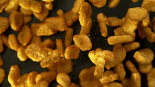 Super Slow Motion of Flying Fried Chicken Pieces on Black Background. Filmed on High Speed Cinema Camera, 1000fps. Speed Ramp Effect.