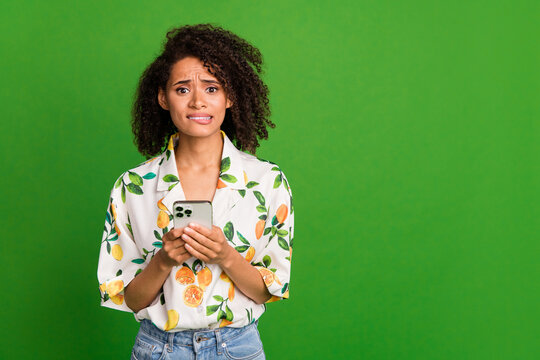 Photo of uncertain stressed woman dressed print shirt communicating modern gadget empty space isolated green color background