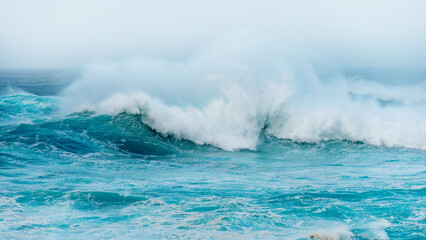Naklejka premium Blue ocean waves abstract background. Rough sea water during stormy weather. Surface of sea wave splash