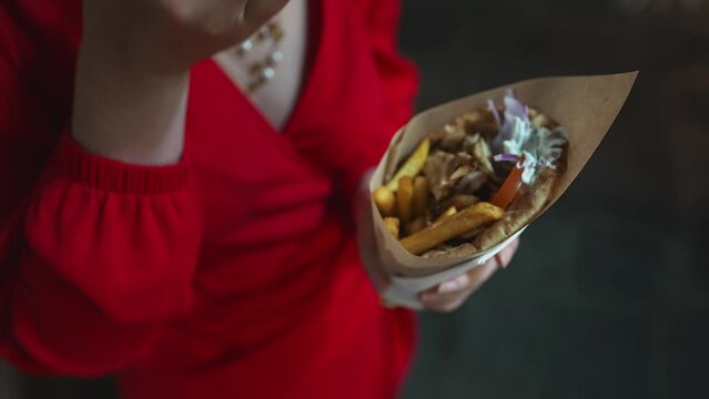 Woman eats pita with french fries.
