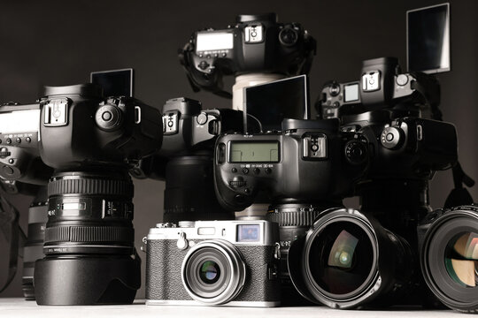 Modern cameras on white table, closeup. Professional photography equipment