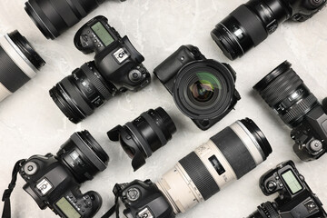Modern cameras on gray marble table, flat lay