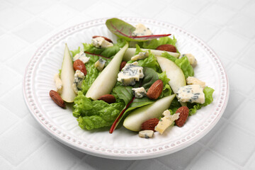 Delicious pear salad on white tiled table, closeup