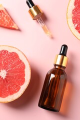 Flat lay composition with grapefruit essential oil on pink background