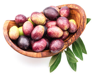 Colorful semi-ripe and ripe olives in wooden bowl isolated on white background.