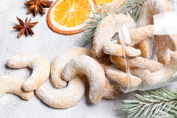 Christmas horseshoe cookies, bagels with powdered sugar. Christmas tree branches for decoration. Light background