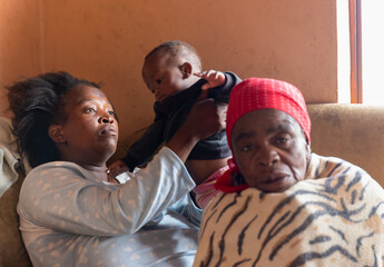 african refugee destitute family  bonding  together in the corner of a room, poverty, inside the...