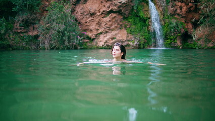 Sexy lady swimming nature pool. Seductive naked woman looking camera at lagoon