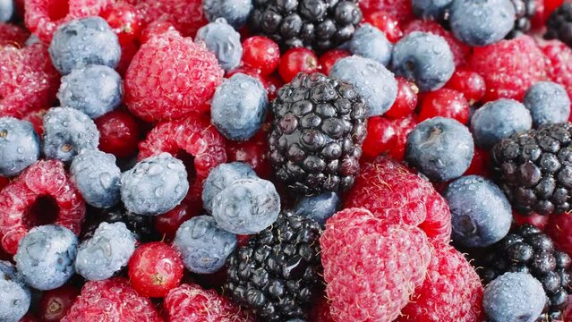 Pattern Fresh raspberries, blackberries, blueberries, red currants rotate top view close up. Healthy fruit berries.Pattern Fresh fruit snack. Vitamin K. Summer concept 