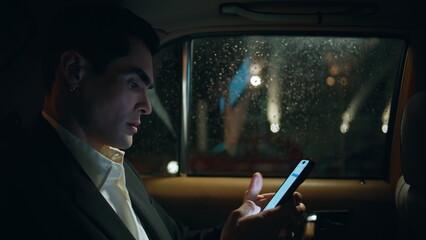 Handsome businessman working smartphone vehicle closeup. Manager sitting taxi