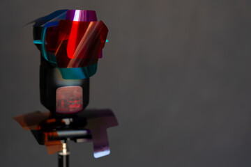 flash montado en tripié con múltiples geles de colores