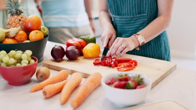 hand, knife and vegetables prepare in kitchen for healthy lunch snack or fruit for nutrition, recipe or pepper. Person, cutting and board or carrots as raw ingredient for salad diet, vegan or organic