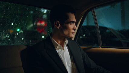 Handsome businessman looking car window at night closeup. Man travelling auto 