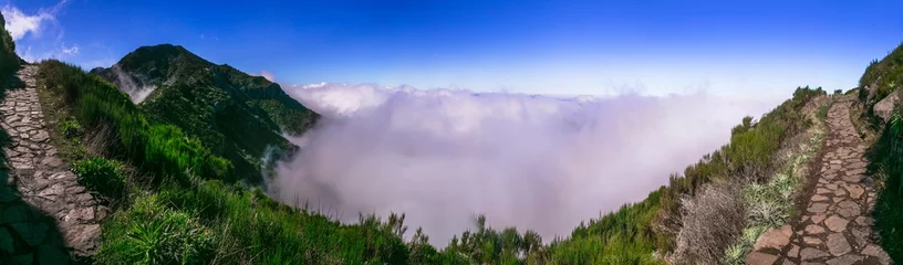 Gordijnen Hiking activity in Madeira island rocky mountains. Trail for Pico Ruivo highest point passing in the clouds. © Freesurf