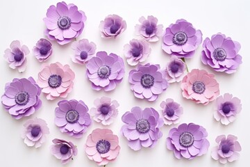  a bunch of paper flowers sitting on top of a white table with purple and pink flowers in the middle of the petals and the middle of the flowers in the middle of the petals.