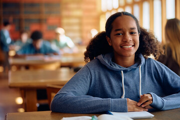 Happy black high school student in classroom looking at camera.