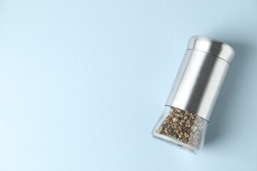 Pepper shaker on light background, top view. Space for text