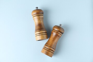 Wooden salt and pepper shakers on light background, top view