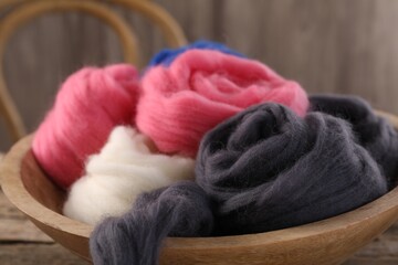 Fototapeta na wymiar Colorful felting wool in bowl on table, closeup