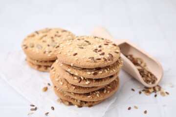 Cereal crackers with flax and sesame seeds on white tiled table, closeup