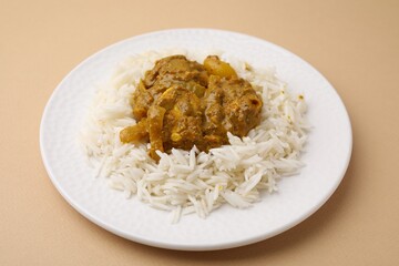 Delicious chicken curry with rice on beige background, closeup