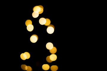 Golden blurred bokeh lights on black background. Christmas lights overlay.