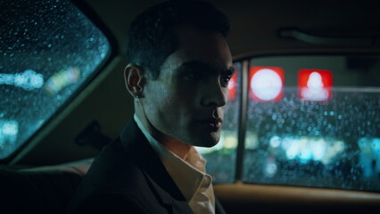 Focused manager turning window rainy evening closeup. Businessman riding vehicle