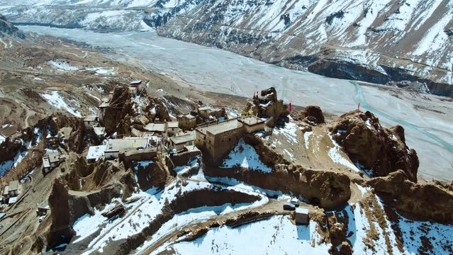 4K aerial view of Dhankar monastery in mountains during winter in Spiti Valley, India. Winter Spiti. Travel and holidays concept. Monastery on Cliff in Himachal Pradesh.