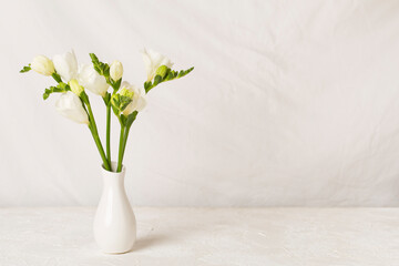 Nice bouquet of white freesia flowers in vase on table - obrazy, fototapety, plakaty