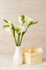 Nice bouquet of white freesia flowers in vase on table