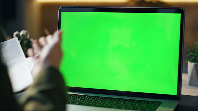 Unknown person talking online conference looking laptop green screen close up.