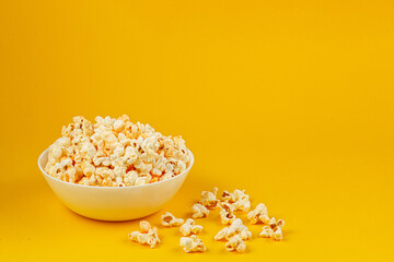 Fototapeta na wymiar plate with popcorn on a yellow background
